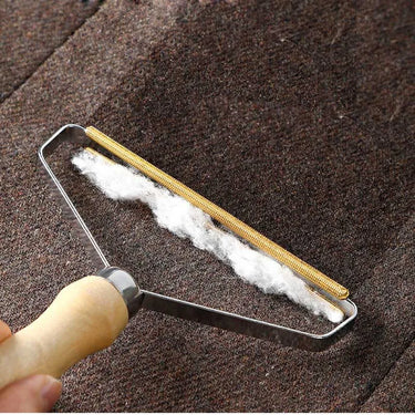 Using the KittyNook Cat Co. Portable Pet Hair Lint Remover to clear white lint from dark fabrics; perfect for pet hair removal.